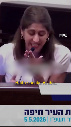 Frame from a video taken at the city council meeting in Haifa, Israel 

It shows Sally Abed speaking, with the caption in English saying "Haifa speaks 
Arabic".